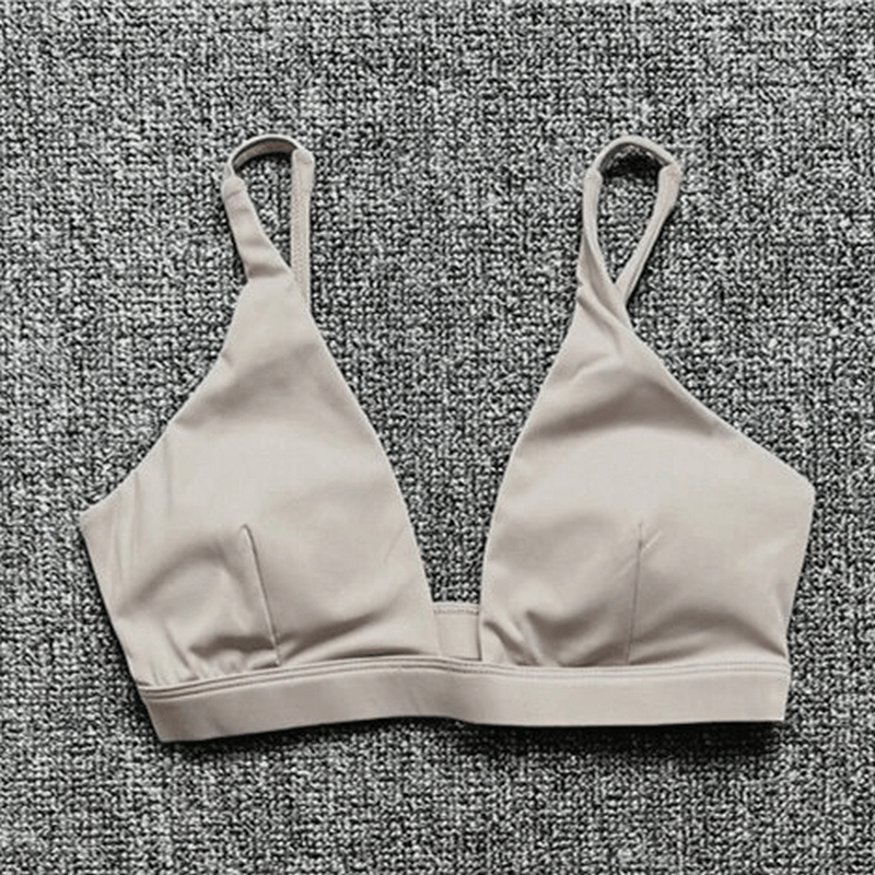 Women's quick-drying sports bra with deep neckline, breathable nylon, solid pattern, ideal for yoga and active pursuits.
